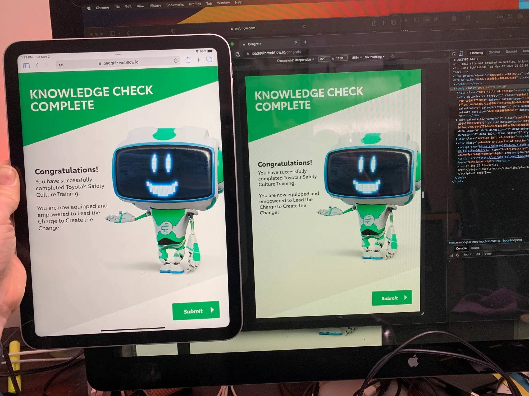 Two tablets and a monitor side by side displaying the "Knowledge Check Complete" screen of the Toyota safety training, with its friendly green robot mascot.