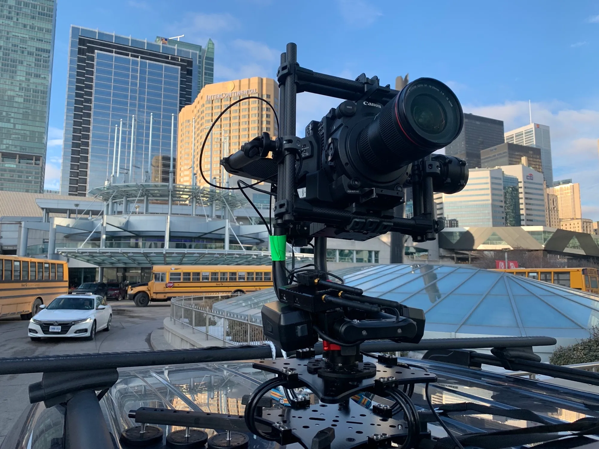 A gimbal-mounted cinema camera rigged on a rooftop overlooking the downtown Toronto skyline.